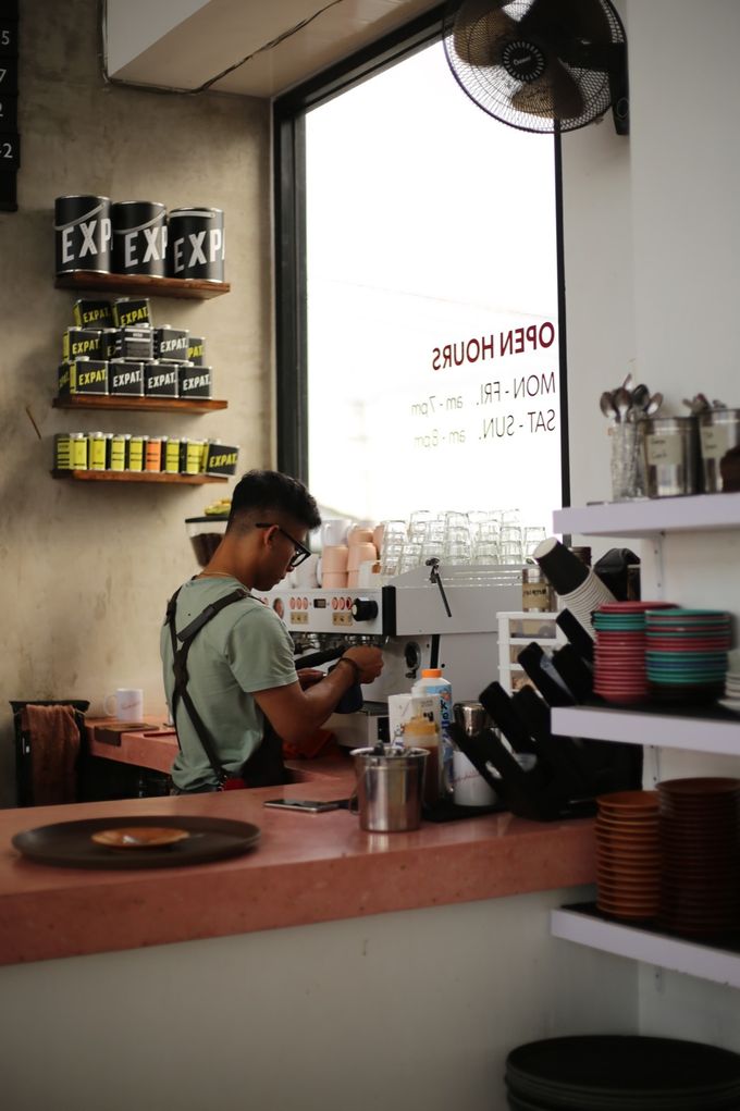 Barista working at the espresso machine by the window