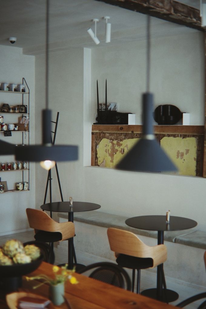 Minimal café with black pendant lamps and wooden bar stools