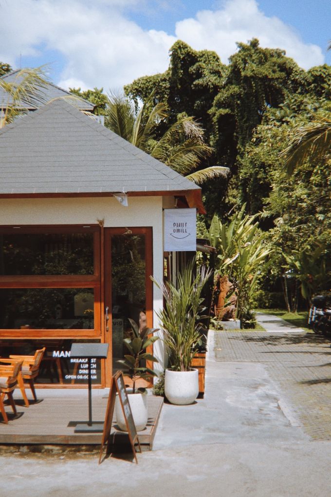 Small café pavilion with timber doors among tropical trees