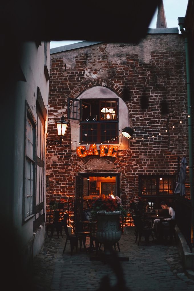 Brick building with a glowing “Café” sign at dusk