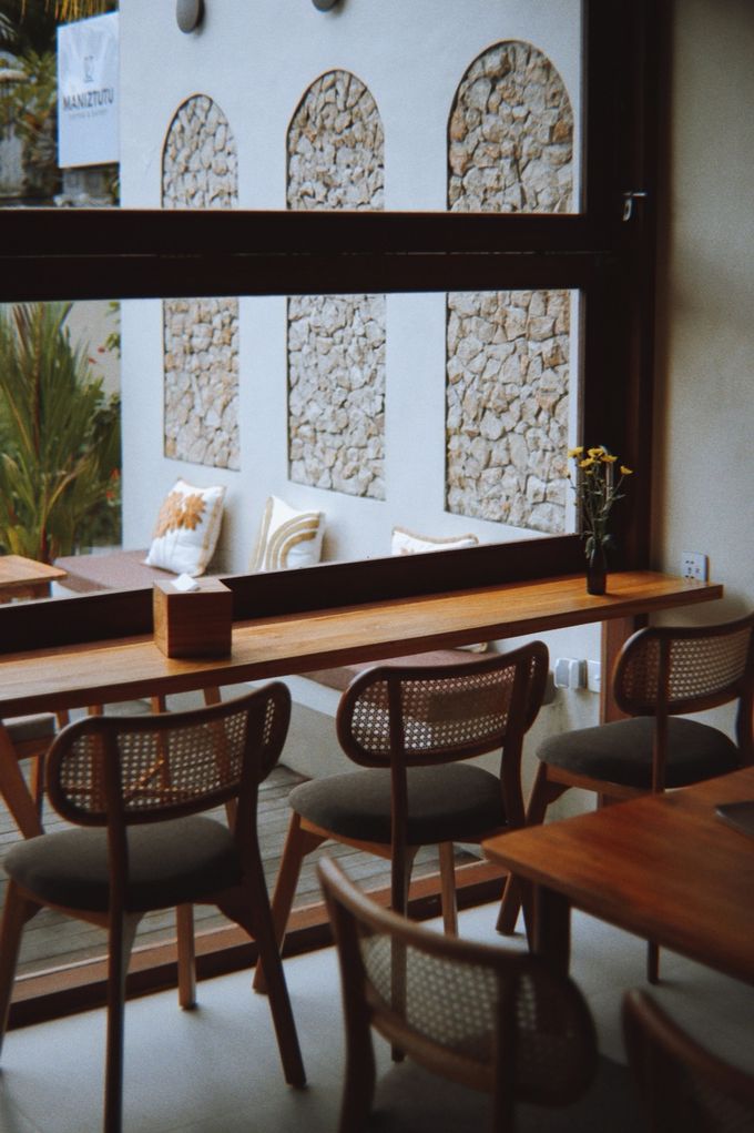 Window seating with rattan chairs and arched stone panels