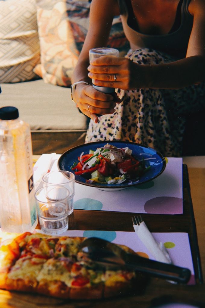Salad and pizza on a table beside a patterned dress